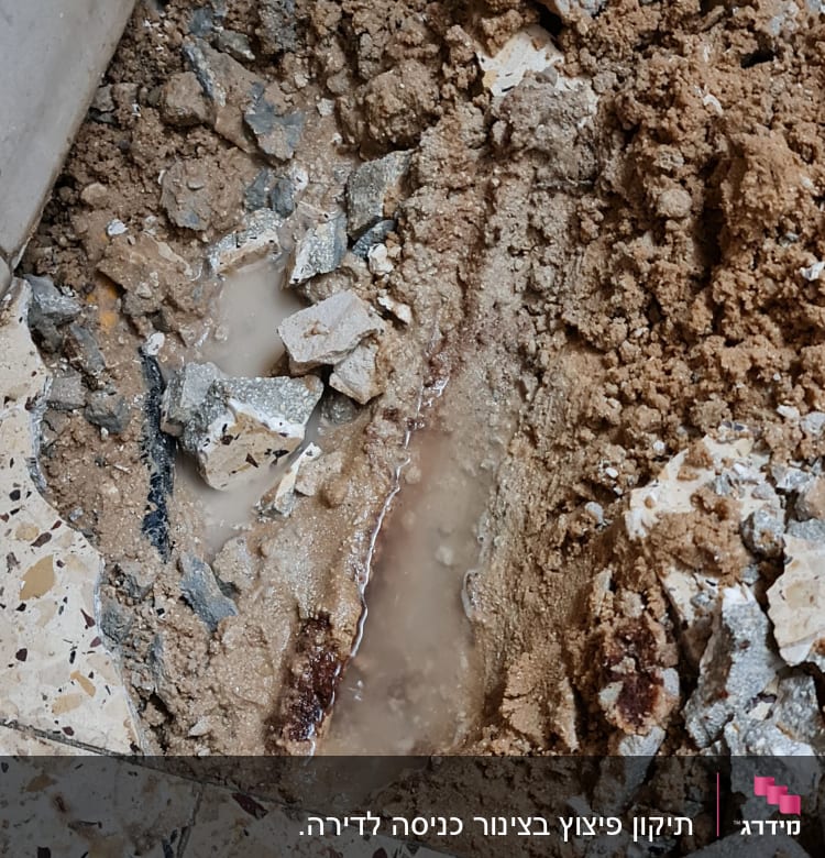בור ברצפה עם מים ופסולת בנייה